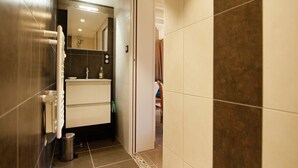 A modern bathroom with a white sink, mirror, and towel rack. - Chalet in picturesque medieval village (Segur-Le-Chateau)