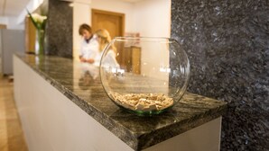 Eine Glaskugel mit hölzernen Buchstaben auf einer Marmorplatte in einer Hotelhalle.