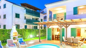 A two-story building with a pool area, outdoor seating, and a barbecue grill. - Beautiful villa with spacious terrace and private swimming pool, on the Croatian island of Hvar (Hvar)