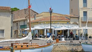 A waterfront restaurant with outdoor seating and a view of boats.