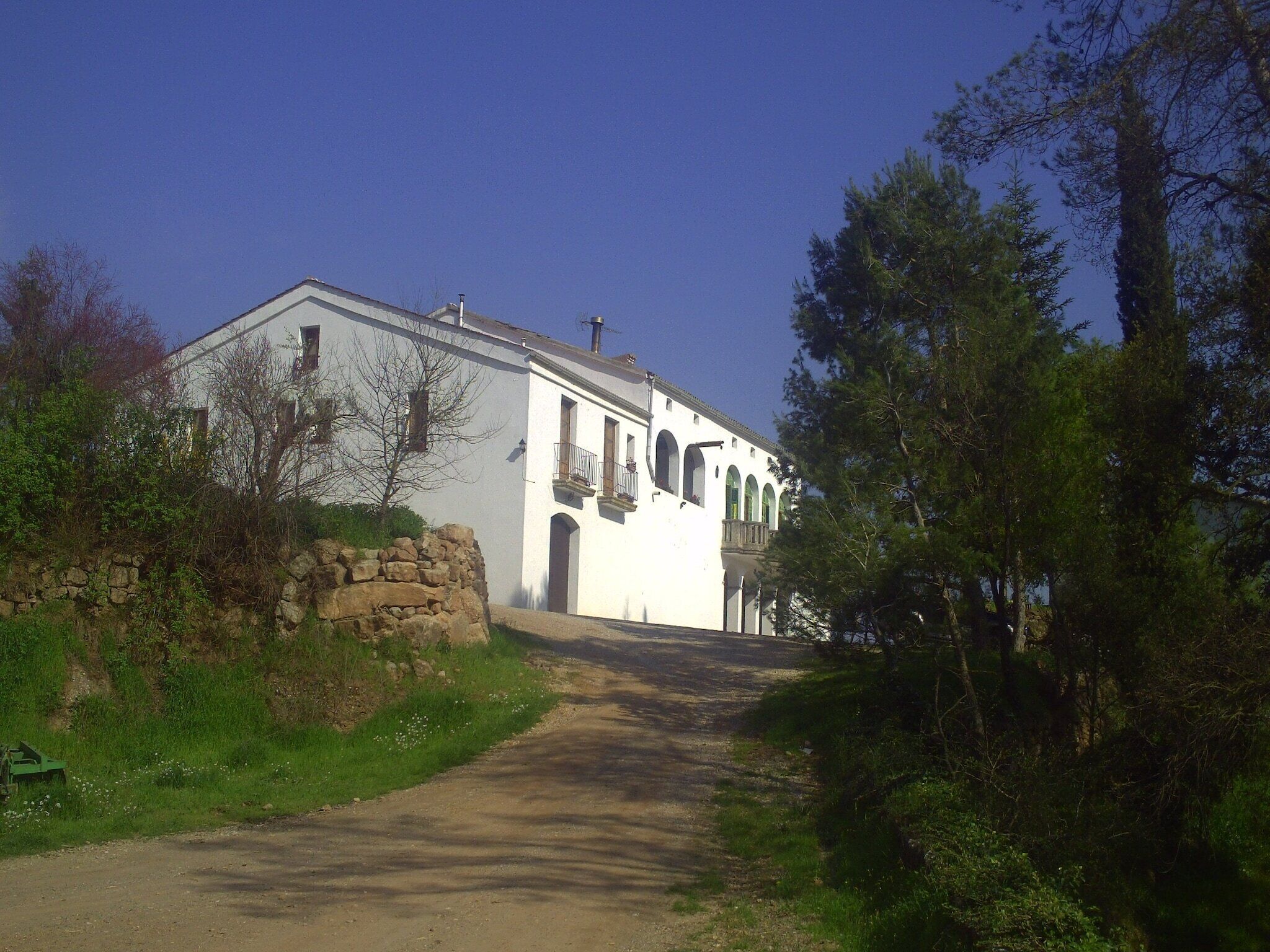 Un edificio blanco con ventanas arqueadas y una pared de piedra.