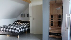 A bedroom with a bed, a wardrobe, and a built-in shelving unit. - Holiday Home in Langweer with Infrared Sauna (Langweer)