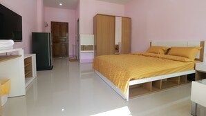 A modern bedroom with a bed, wardrobe, and a television.