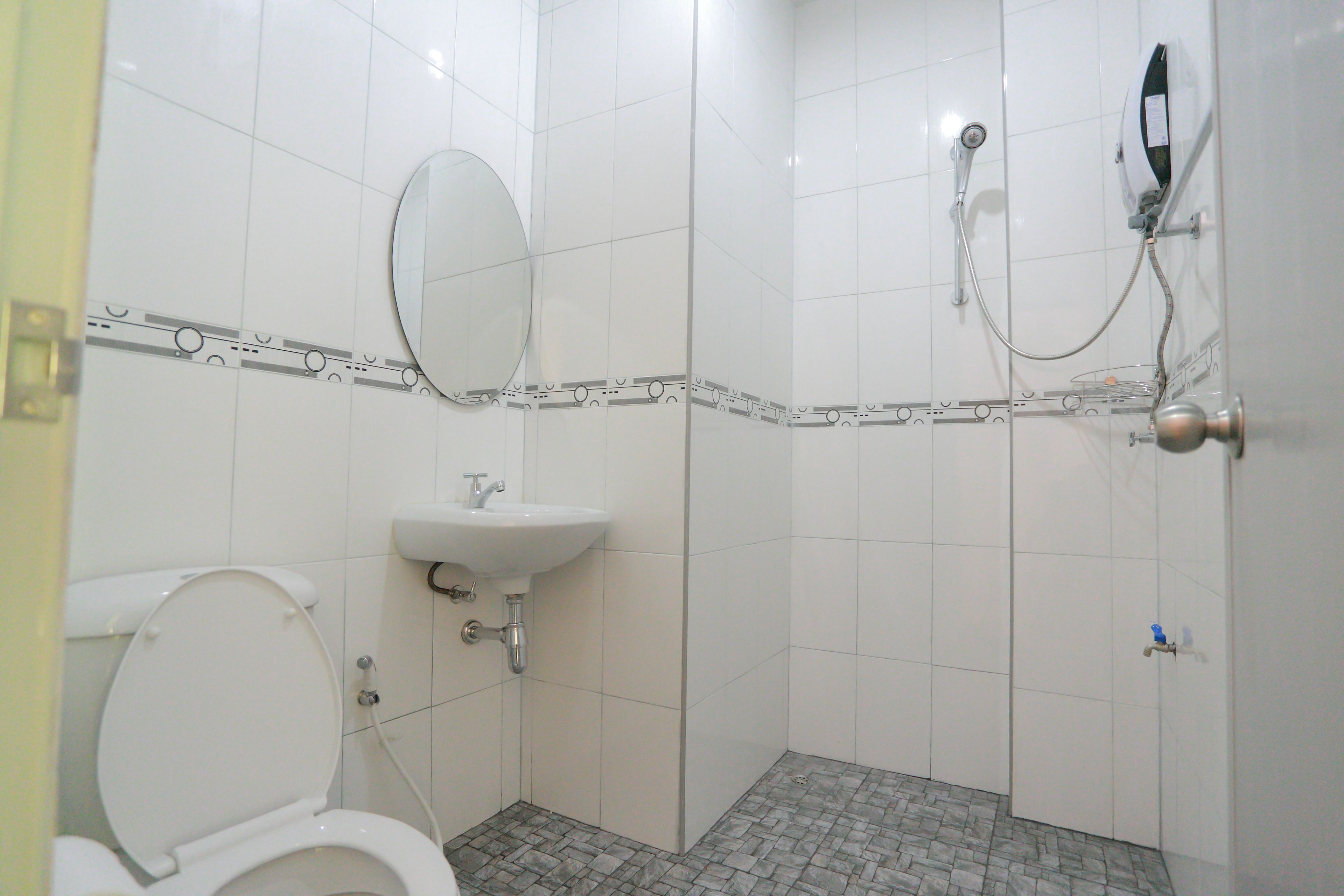A bathroom with a toilet, sink, and shower.