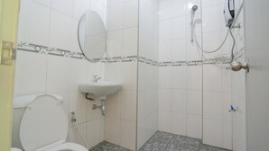 A bathroom with a toilet, sink, and shower.