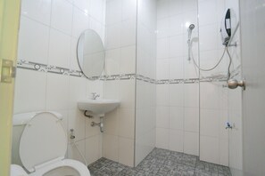A bathroom with a toilet, sink, and shower.