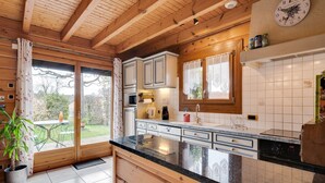 Eine Küche mit Holzausbau, einer schwarzen Arbeitsplatte und einer Uhr an der Wand.