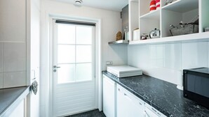 A compact kitchen with white cabinets, a black countertop, and a microwave. - Cottage in Ovezande with terrace (Ovezande)