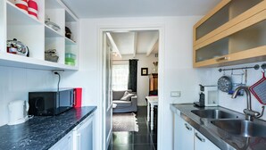 A compact kitchen with a black countertop, a microwave, a coffee maker, and a sink. - Cottage in Ovezande with terrace (Ovezande)