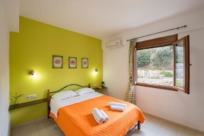 A bedroom with a bed, green walls, a window, and a view of the outdoors. - Armonia Villa by LeaderStay (Mylopotamos)