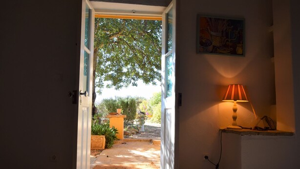 An open doorway leading to a garden area with a lamp on the right. - Algarve Casa with Pool (Loulé)