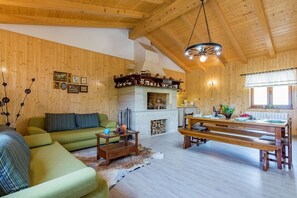 Relax in this inviting living room with a fireplace, comfortable sofa, and dining area.