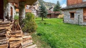 A rustic mountain lodge with stone walls, wooden balconies, and a grassy courtyard. - Lake-view chalet in Tignes, close to ski area (Tignes)