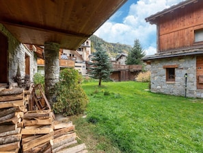 A rustic mountain lodge with stone walls, wooden balconies, and a grassy courtyard. - Lake-view chalet in Tignes, close to ski area (Tignes)