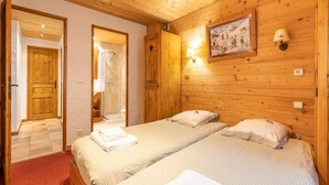 A wooden-paneled room with two beds, a shower, and a painting on the wall. - Lake-view chalet in Tignes, close to ski area (Tignes)