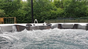 A hot tub with water flowing out of a spout, surrounded by lush greenery. - Elegant Villa in Bomal (Bomal-Sur-Ourthe)