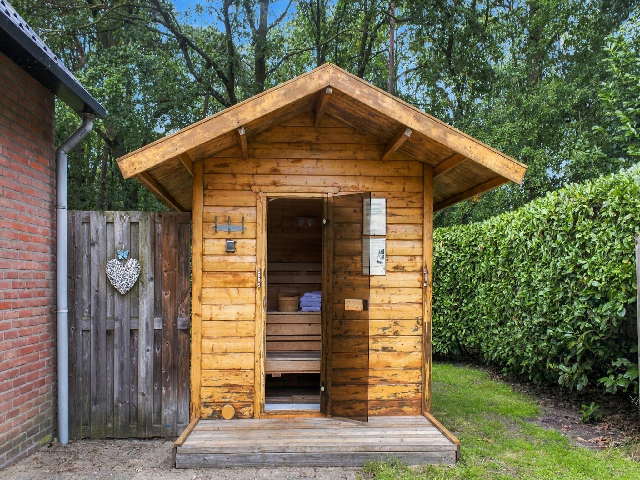 A wooden cabin with a pitched roof, a door, and a small porch.