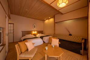 Habitación de hotel con dos camas, un sofá, una mesa y un televisor.