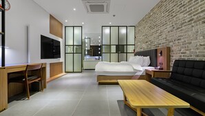 A modern hotel room with a bed, a desk, a sofa, and a TV. - Schweizer Dorf Hotel (Cheonan)