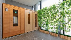 A hallway with wooden lockers, a tiled floor, and a bamboo plant wall. - Schweizer Dorf Hotel (Cheonan)