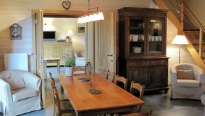 A dining area with a wooden table, chairs, and a cabinet with glass doors.