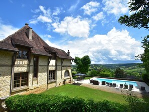 A stone house with a swimming pool and a view of the countryside.