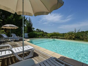 A poolside area with lounge chairs and umbrellas, surrounded by greenery. - Loubejac Garden Escape (Loubéjac)