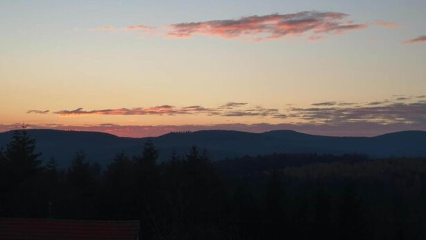 A sunset view with mountains in the background and trees in the foreground. - Spacious Chalet for 4 in Hommert (Hommert)