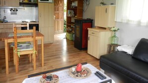 A compact living space with a kitchen, dining area, and a small seating area. - The charm of a wooden chalet with a magnificent view, not far from Spa (Stoumont)