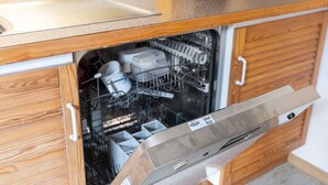 A kitchen with wooden cabinets and a dishwasher. - Apartment in Matrei near Ski Slopes (Matrei in Osttirol)
