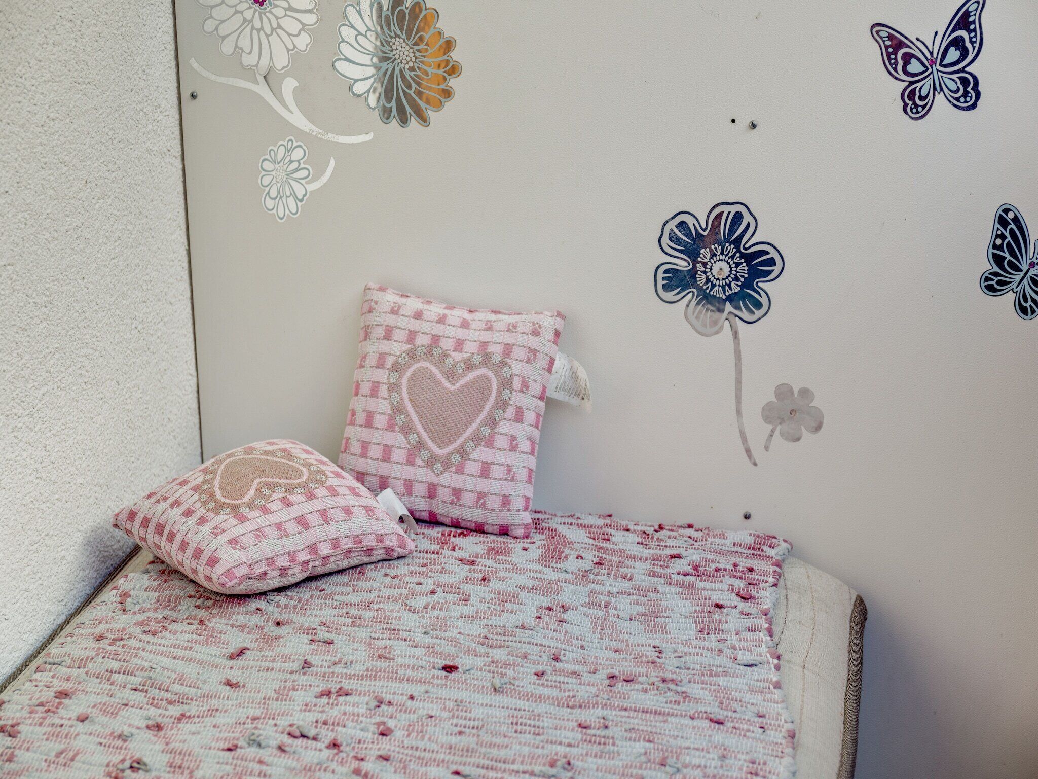 Une petite pièce agréable et confortable, avec un lit, des oreillers et des autocollants décoratifs sur les murs.