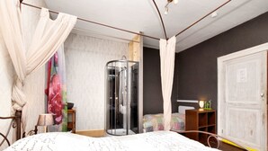 Un dormitorio con cama, cabina de ducha de vidrio, mesita de noche, armario y cortina.