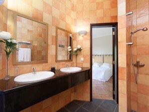 Ein Badezimmer mit zwei Waschbecken, einem großen Spiegel und einer Duschkabine.