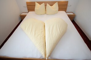 A bed with a heart-shaped pillow arrangement.