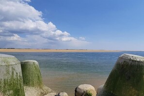 A coastal scene with a sandy beach, calm water, and a clear sky. - Apartment in Erdeven near Kerhillio Beach (Erdeven)
