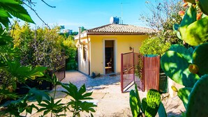 A small yellow house with a tiled roof, surrounded by greenery and a cactus. - Holiday Home in Lido di Noto near Beach (Lido di Noto)