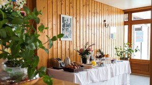 A breakfast buffet setup with a wooden wall, a framed photo, and various food items. - Apartment in Evian with Lake Geneva View (Bernex)