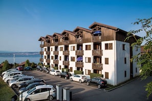 Un hôtel à plusieurs étages doté de balcons, d’un parking et offrant une vue sur la mer.