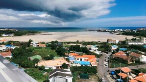 Un poble costaner amb platja, cases i carretera.