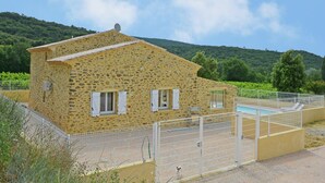 A stone building with a fenced pool area. - Beautiful villa with private pool in Gard (St.Laurent de Carnols)