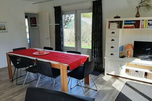 Cozy living space with a dining area, television, and large window.