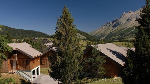 A cluster of wooden cabins with a mountain backdrop. - Spacious Alpine Chalet (Le Devoluy)