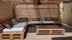 Un intérieur en bois avec un canapé et une petite table, une lanterne suspendue au plafond et un mur en bois.