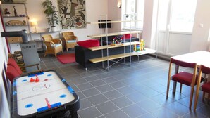 A room with a foosball table, a sofa, a TV, and a bookshelf. - Child-friendly holiday home in Moravia with a beautiful location and view (Nedvedice)