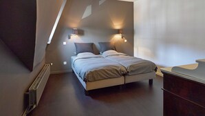 Ein Schlafzimmer mit einem Bett, zwei Nachttischlampen, einem Schminktisch und einer Heizung.