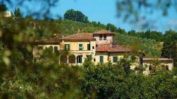 Un edificio ampio e a più piani, caratterizzato da uno stile architettonico tradizionale, immerso nel verde.
