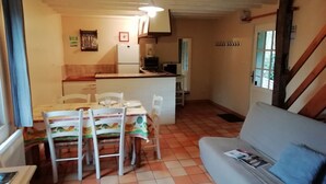 A compact living space with a dining area, kitchenette, and a sofa. - Holiday Home in Quend-Plage near Forest (Quend-Plage)