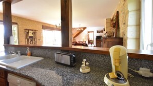 A kitchen with granite countertops, a toaster, a coffee maker, and a dishwasher.