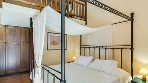A four-poster bed with white linens, a wooden ceiling, and a nightstand with a lamp. - Villa in Crete with Private Pool & Views (Malades)
