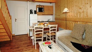 A compact living space with a kitchenette, dining area, and a sofa.